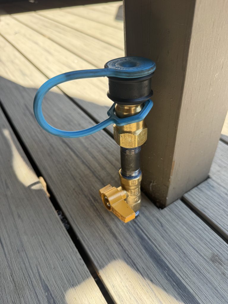 Capped gas line stub-out with a shutoff valve installed at a deck post for a grill hookup