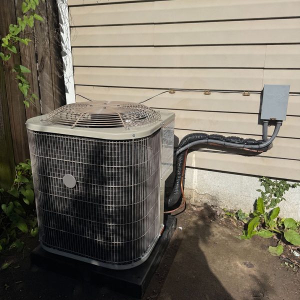 New air conditioner condenser and line set installed after the old unit and overgrowth were cleared